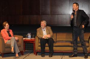 Gwen (left) on stage at a cancer summit with Lance (right). Time to pass the mic.